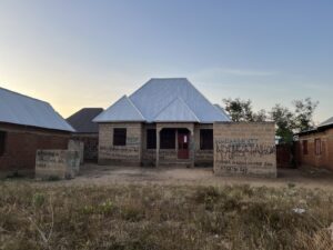 "The CRDB Bank is selling this house," reads a sign in the village of Dumila.